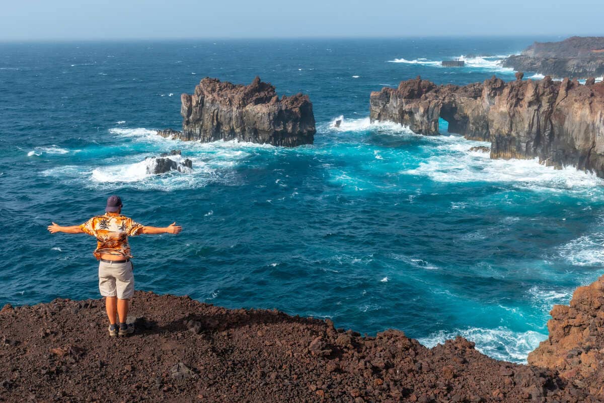 Young Man Taking A Picture At A Cliff In El Hierro, Canary Islands, Spain