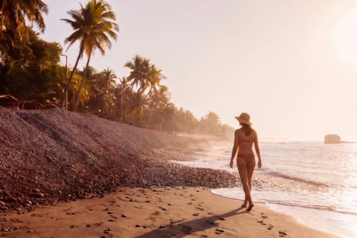 Woman walking along the beach in El Tunco, El Salvador